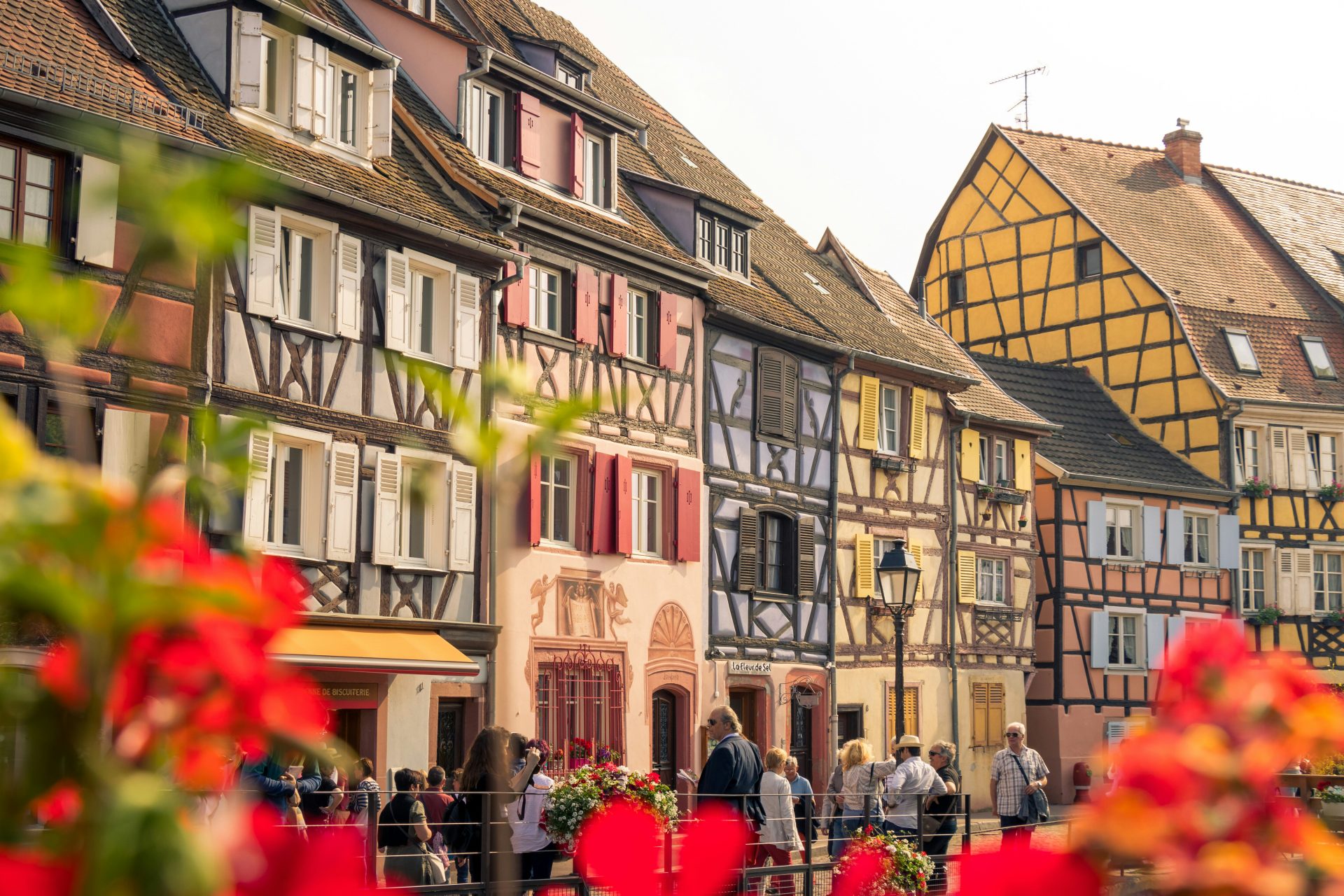 people walking beside assorted-color buildings during daytime
